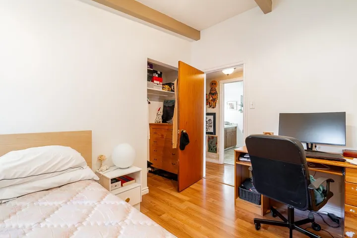 Bedroom with beam ceiling and light wood-type flooring