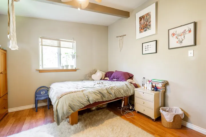 Bedroom featuring wood finished floors, baseboards, and beamed ceiling