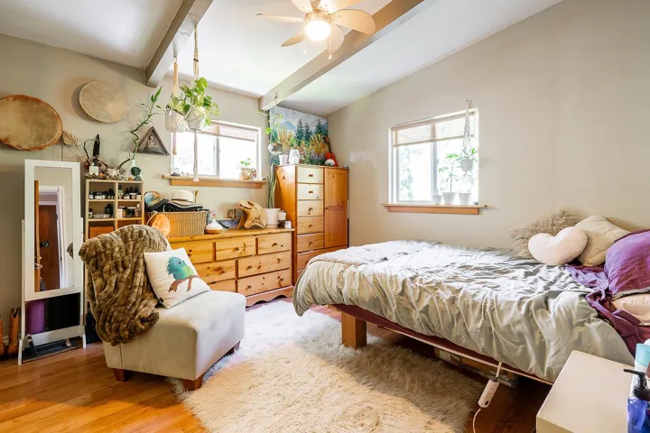 Bedroom with beam ceiling, a ceiling fan, and wood finished floors