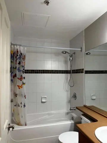 Bathroom featuring shower / bath combination with curtain and vanity