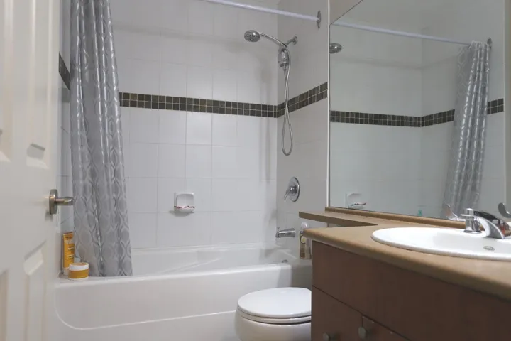 Bathroom with shower / bath combo with shower curtain and vanity