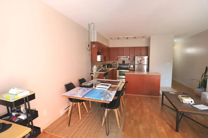Dining space with light wood-type flooring, rail lighting, and a baseboard radiator
