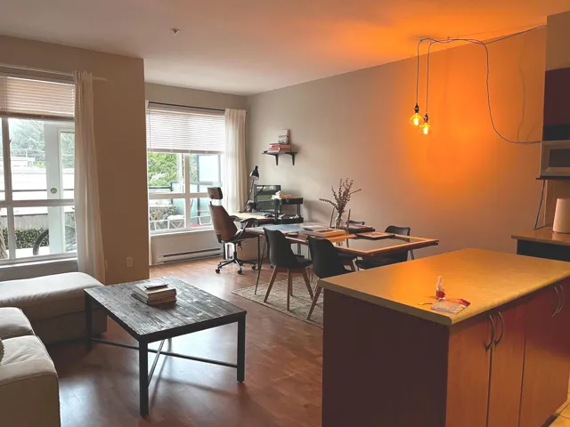 Living area with an office area, wood finished floors, and baseboard heating