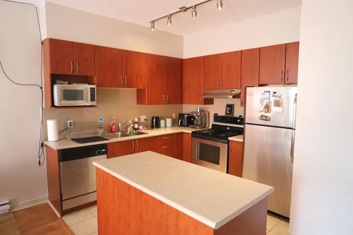 Kitchen with appliances with stainless steel finishes, tasteful backsplash, light countertops, and light tile patterned floors
