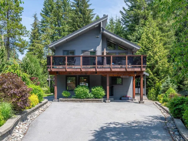 View of front of property featuring driveway and a wooden deck
