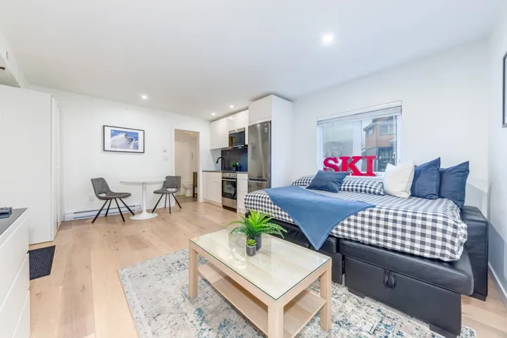 Living room featuring light wood-type flooring, recessed lighting, and a baseboard heating unit