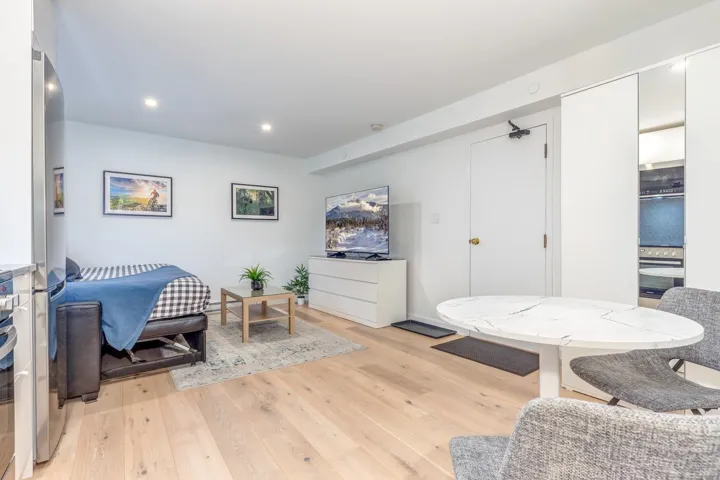 Living area featuring light wood finished floors and recessed lighting