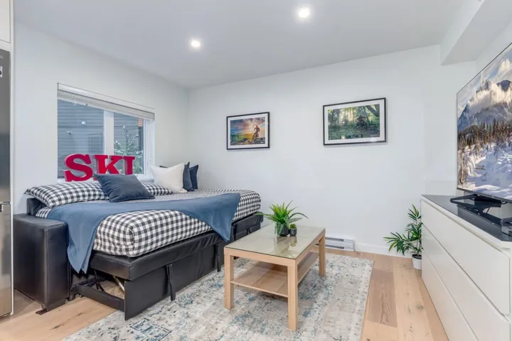 Bedroom with light wood-style floors, a baseboard heating unit, and recessed lighting