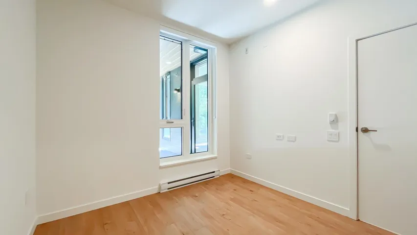Empty room with a baseboard radiator and light wood-style floors