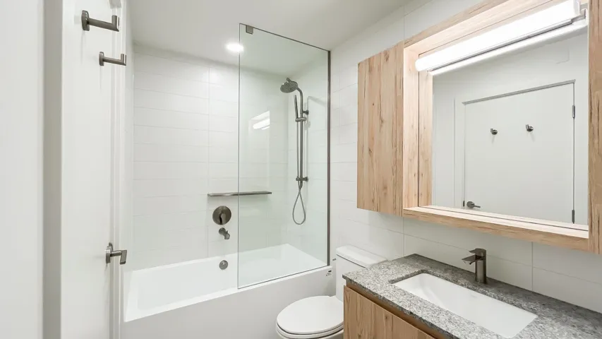 Full bath featuring tile walls, vanity, tub / shower combination, and decorative backsplash