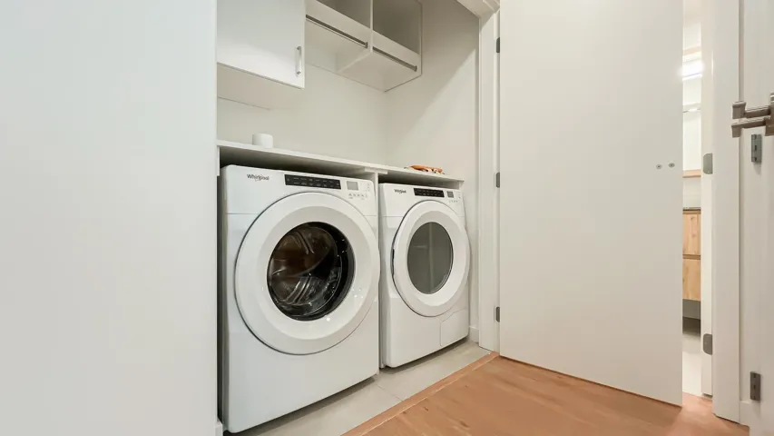 Laundry room featuring light wood-style floors and washing machine and clothes dryer