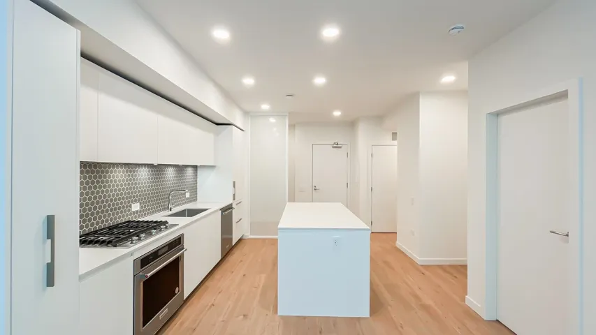 Kitchen with stainless steel appliances, a center island, white cabinetry, tasteful backsplash, and modern cabinets