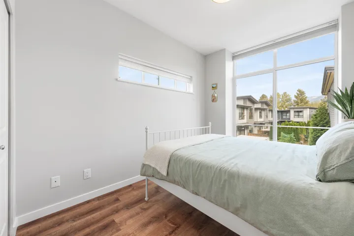 Bedroom featuring dark wood-style floors and baseboards