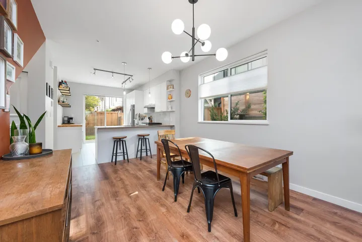 Dining room featuring light wood-style floors, rail lighting, and a chandelier