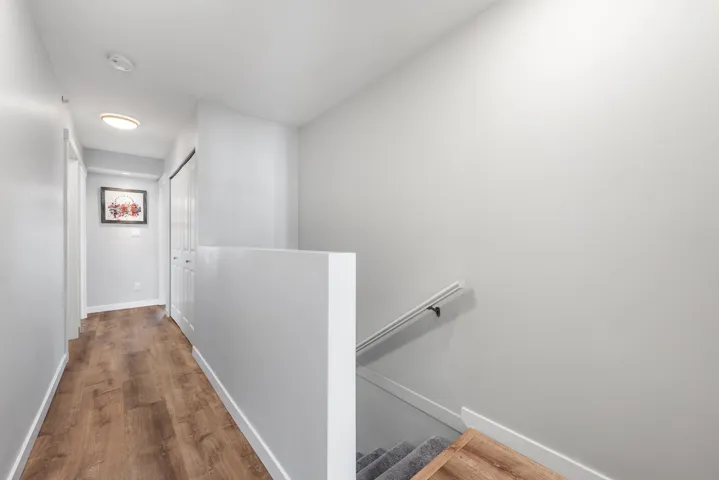 Hall with dark wood-style flooring and an upstairs landing
