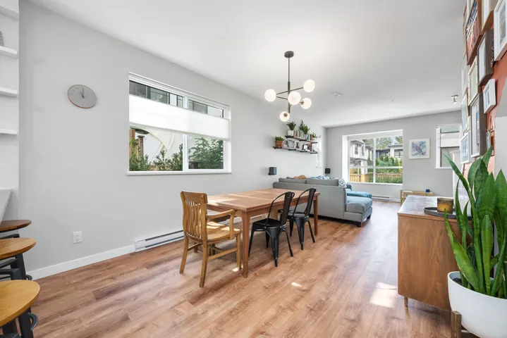 Dining room featuring light wood finished floors, baseboard heating, and a chandelier