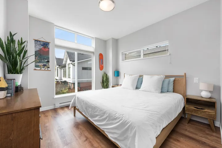 Bedroom featuring wood finished floors and a baseboard heating unit