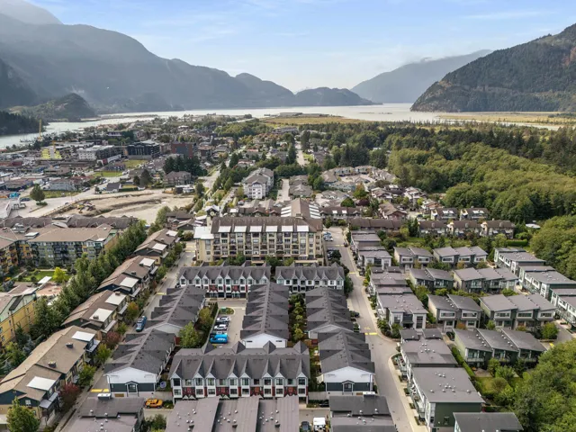 Aerial view of property's location with a water and mountain view and nearby suburban area