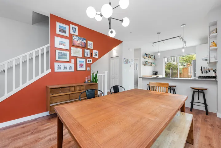 Dining area with light wood-style flooring, stairs, a chandelier, and track lighting