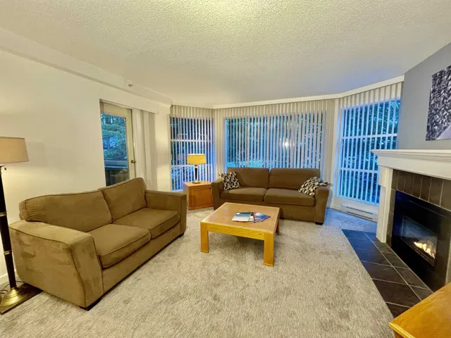 Tiled living room with a textured ceiling and a tile fireplace