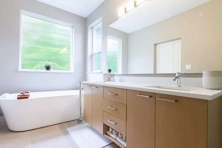 Full bath with double vanity, a soaking tub, and a sink