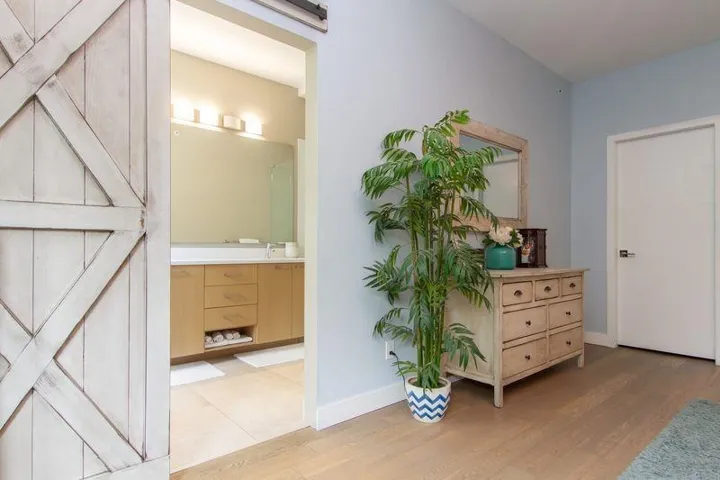 Interior space with light wood finished floors, a barn door, and baseboards