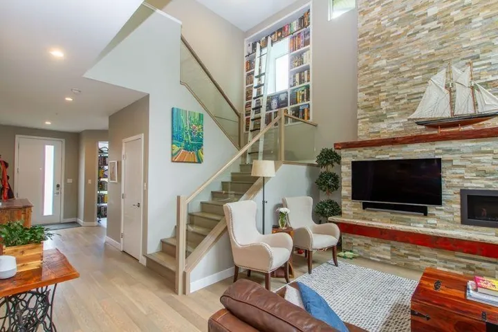 Living room featuring stairs, recessed lighting, baseboards, and wood finished floors