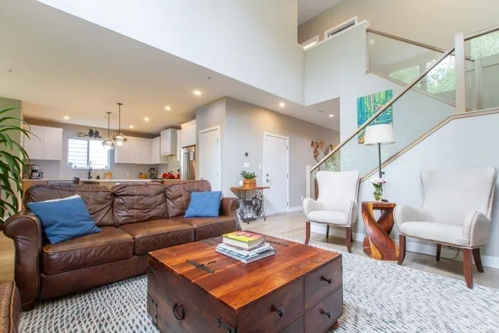 Living room featuring recessed lighting, baseboards, light wood finished floors, and a high ceiling