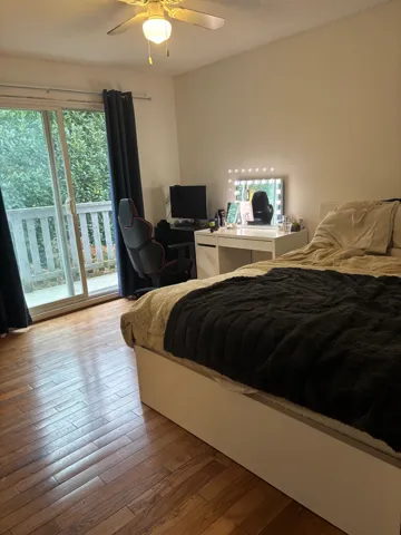 Bedroom with wood-type flooring, a textured ceiling, and a ceiling fan