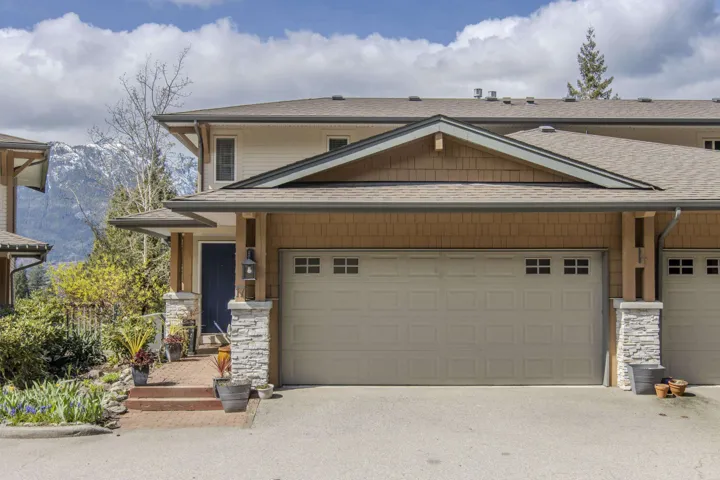 Attached garage featuring decorative windows and a paved driveway