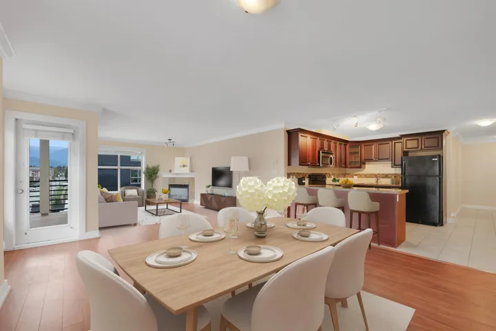 Dining room featuring ornamental molding, a tiled fireplace, light wood-type flooring, and track lighting