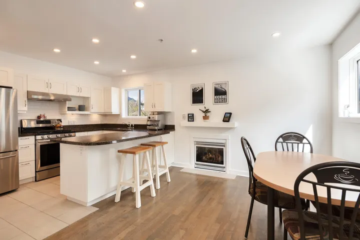 Kitchen with recessed lighting, a peninsula, under cabinet range hood, a breakfast bar area, and appliances with stainless steel finishes