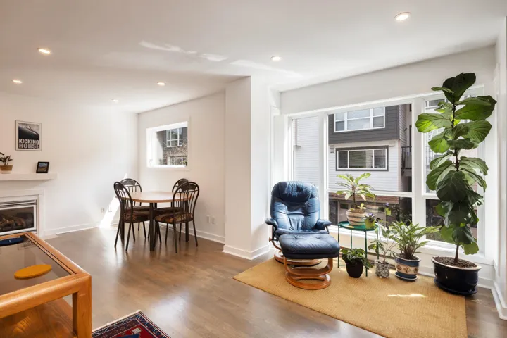 Living room featuring wood finished floors, baseboards, a glass covered fireplace, and recessed lighting