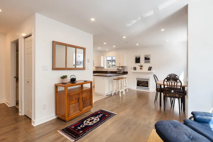 Living room featuring a glass covered fireplace, recessed lighting, baseboards, and wood finished floors