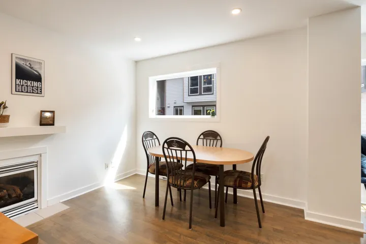 Dining room featuring baseboards, recessed lighting, wood finished floors, and a fireplace with flush hearth