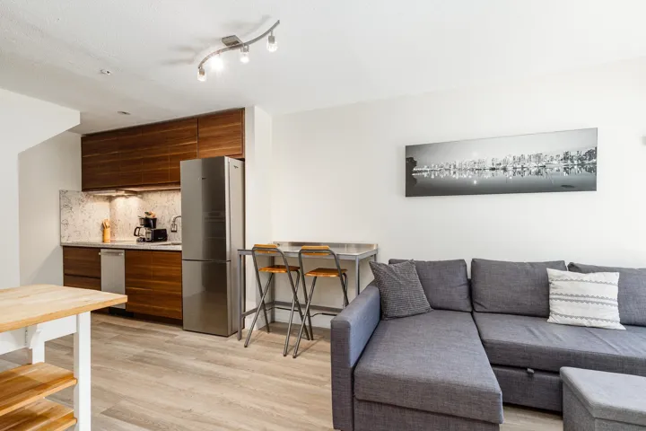 Wood-finish flooring throughout, track lighting, stainless steel refrigerator, integrated dishwasher, and wood-finish cabinetry