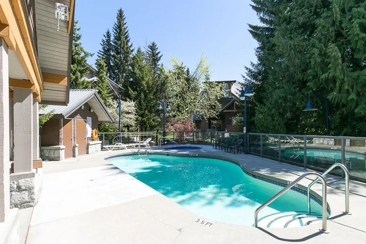 Freeform swimming pool with integrated spa and concrete decking