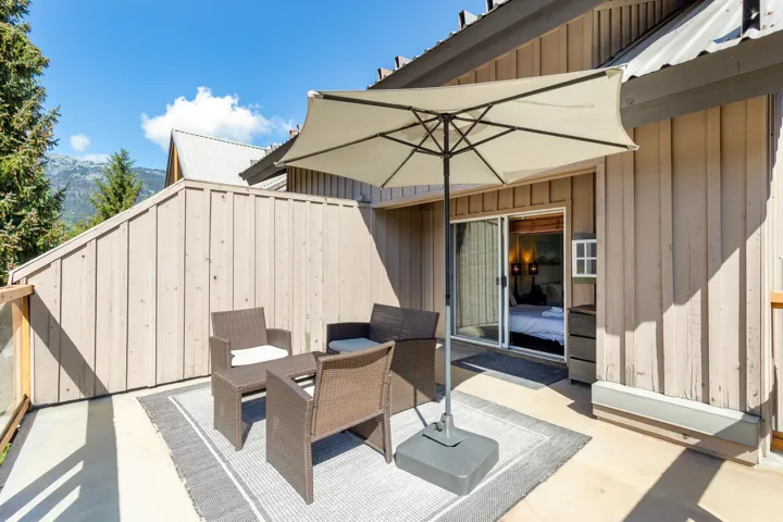 Outdoor concrete patio featuring wood panel siding and a sliding glass door