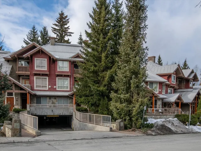 View of front of house with an attached garage, stone siding, and concrete driveway