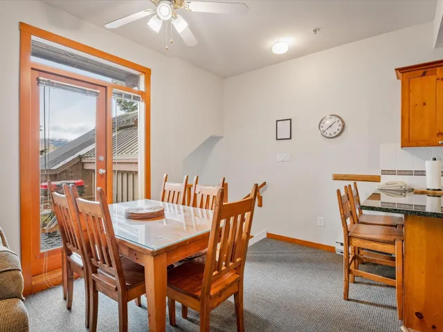 Dining area with light carpet, ceiling fan, and baseboards