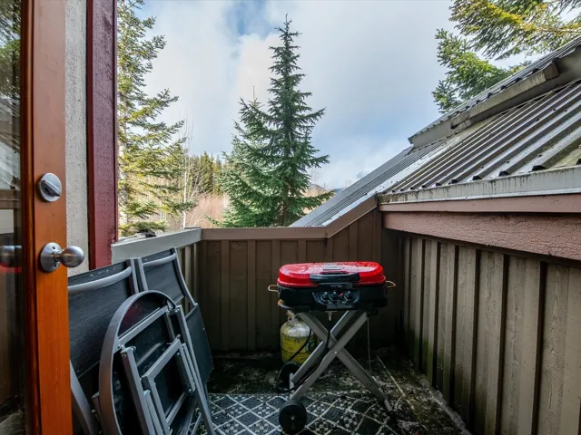 View of patio with area for grilling and a balcony