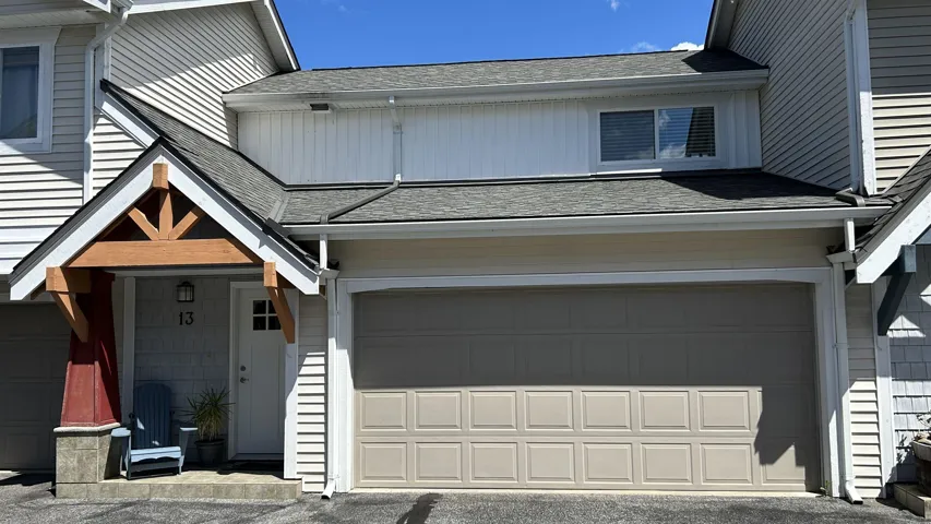 Exterior featuring a covered entryway with timber-style gable bracing, horizontal and vertical lap siding, an attached two-car garage, and asphalt shingle roofing
