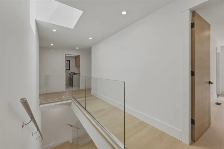 Spacious bathroom featuring a freestanding soaking tub, large window with natural scenery, double vanity with vessel sinks, extensive mirror, and recessed lighting