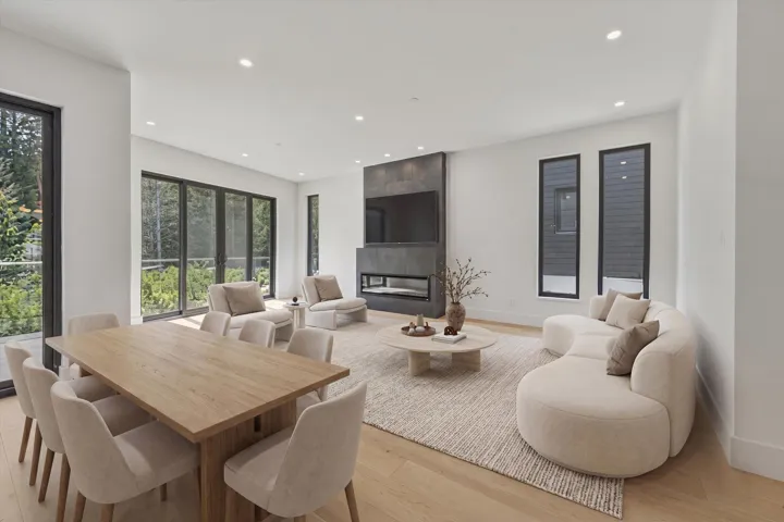 Open-concept living space featuring wood-finish flooring, recessed lighting, and expansive windows