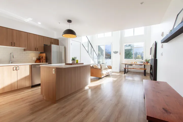 Kitchen with decorative backsplash, stainless steel appliances, light countertops, and light wood-style floors