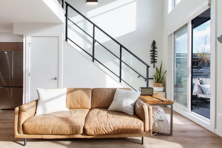 Living area featuring stairs, light wood-style floors, and a towering ceiling