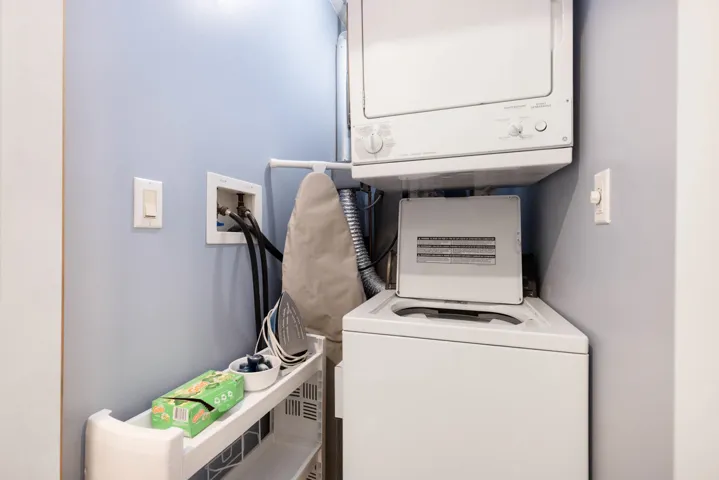 Laundry area featuring stacked washer / drying machine and laundry area