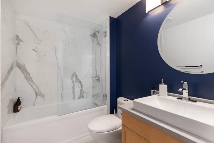 Bathroom featuring toilet, washtub / shower combination, and vanity