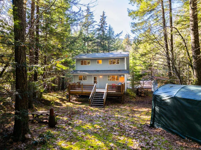 Rear view of house featuring stairway and a wooden deck