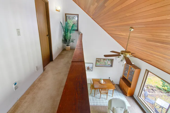 Hall with carpet floors, wooden ceiling, and lofted ceiling